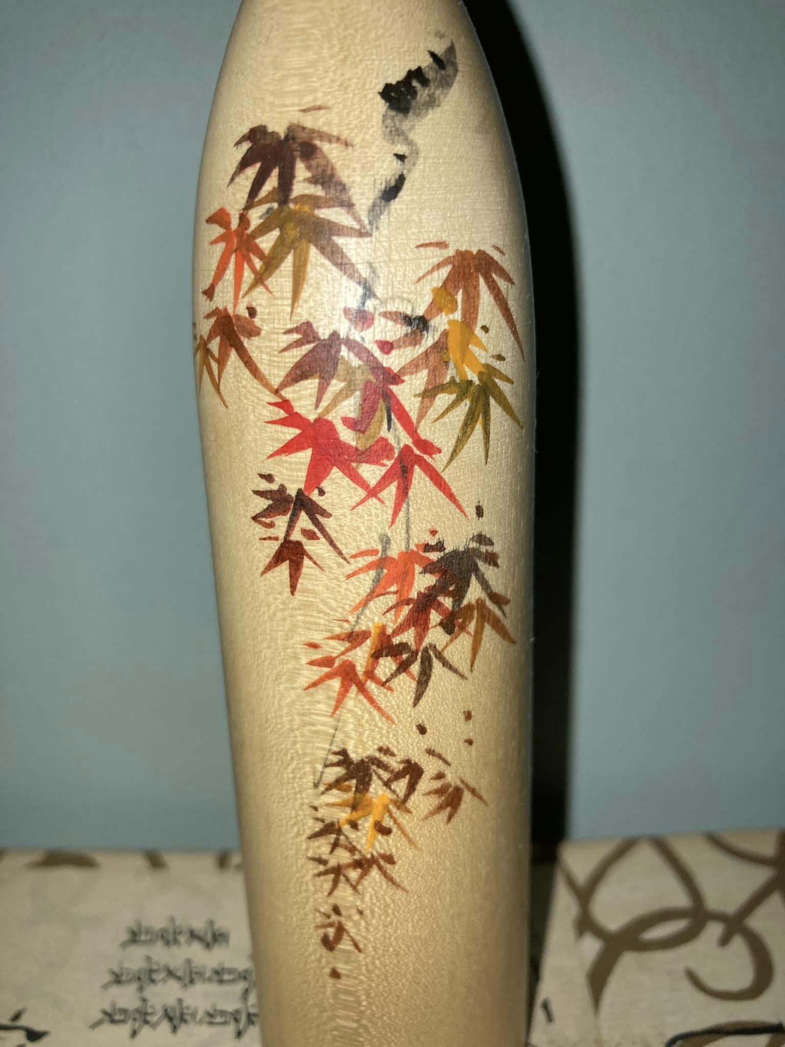 Kokeshi with maple leaves by Watanabe Masao